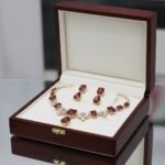 طقم مجوهرات فاخر يتكون من عقد وأقراط مرصعة بأحجار كريمة باللون الأحمر القاني (ياقوتي) محاطة بفصوص من الزركون الأبيض اللامع بت