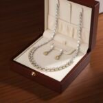 طقم مجوهرات فاخر يتكون من عقد وأقراط مرصعة بأحجار الزركون اللامعة بتصميم، يجمع بوضوح بين اللونين الأبيض الكريستالي والأصفر ال